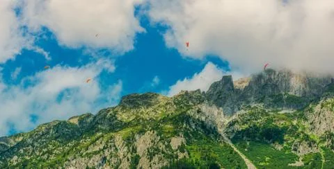 Multiple Paragliders Dive Down Along Peaks Of Mountains In Chamonix France. Stock Photos
