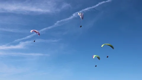 Multiple people parasailing in the sky. Stockbeeldmateriaal 95286716