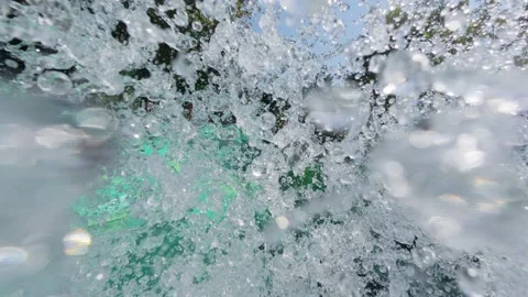 Multiple people racing down a wide, green multi-lane water slide on a sunny day Stock Footage 316398933