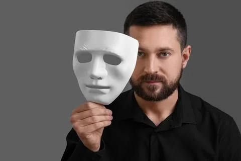 Multiple personality concept. Man with mask on grey background Stock Photos