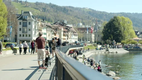 Multiple persons walking  next to a lake Stock Footage 183264921