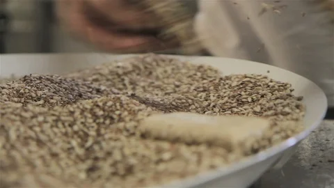 Multiple Perspectives of a Bakery chef rolling portions of bread in cereals Stock Footage 123395939