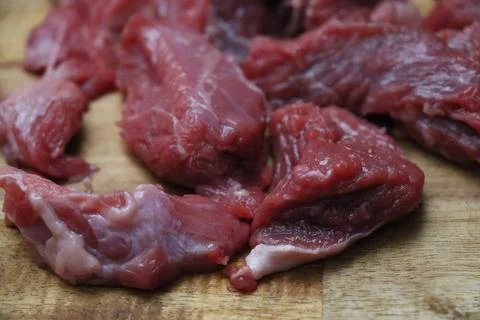 Multiple pieces of cut red beef on kitchen board Stock Photos