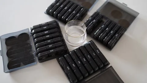 Multiple pill organizers ensure a well-structured routine. Each compartment for  Stock Footage 301106044