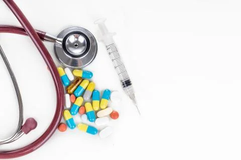 Multiple pills, tablet, caplet, capsule with stethoscope, and syringe. Health Stock Photos