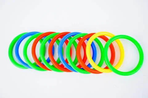 Multiple plastic circle shaped toys arranged on an isolated white background Stock Photos