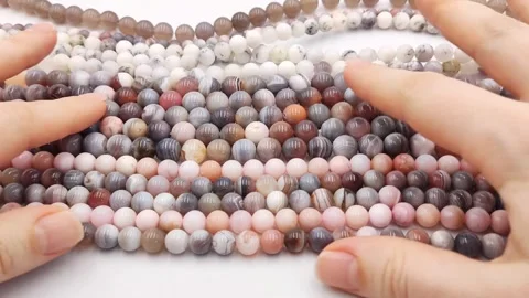 Multiple polished natural gemstone bead strands arranged exhibiting colors Stock Footage 345139711