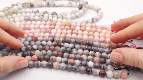 Multiple polished natural gemstone bead strands arranged exhibiting colors Stock Footage 345139719