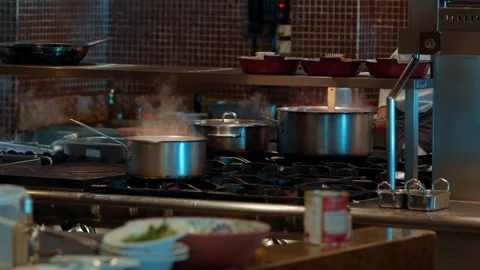 Multiple pots simmering on the line in a busy professional restaurant kitchen Stock Footage 317736711