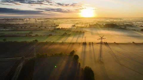 Multiple power lines and pylons stretch the farmland. Stock Footage 253480213