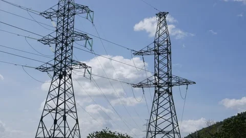 Multiple power lines cross the sky, supported by metal towers, emphasizing large Stock Footage 327594242