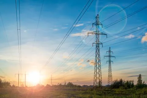 Multiple power lines at the sunset with sun flare. Фото