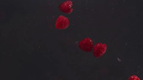Multiple raspberries fruit falling into water and then floating 動画素材 165027548