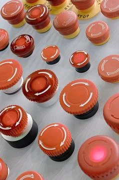 Multiple red emergency stop buttons on a grey metal panel Stock Photos