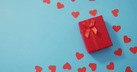 Multiple red paper hearts and red present at valentine's day on blue background Stock Footage 340391611