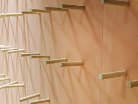 Multiple Rows of Decorative Cylindrical Wood Sticks on the Wall Foto stock