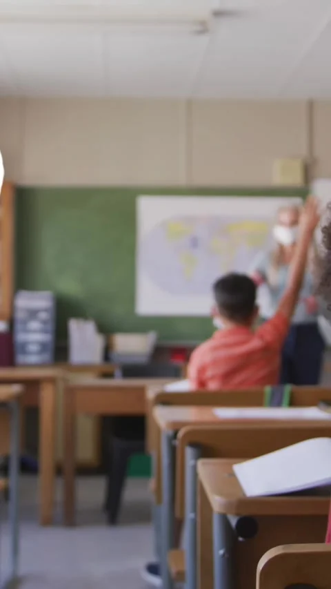 Multiple school concept icons against students raising their hands in the class Stock Footage 343828108