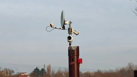 Multiple security cameras and a communication antenna mounted on a pole. Urban Stock Footage 329294041