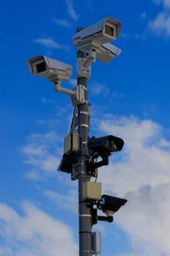Multiple security cameras on pole and blue sky Stock Photos