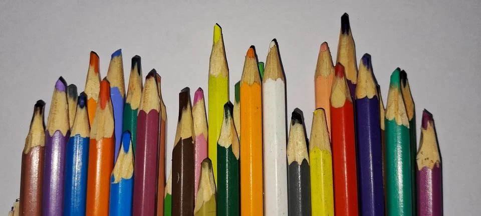 Multiple sharpened colored pencils arranged in a vibrant artistic row formation Stock Photos
