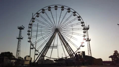 Multiple shots of a young man riding infront of a ferris wheel Stock Footage 142836652