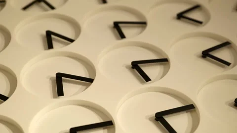 Multiple simple clocks artwork with rotating hands creating pattern hung Stock Footage 233697762