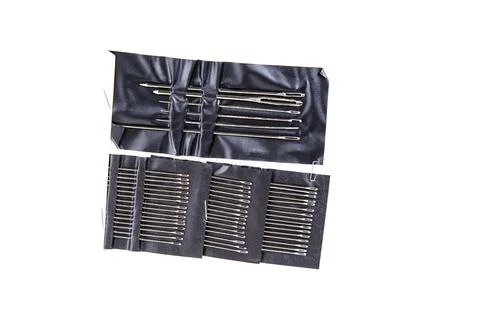 Multiple sized silver sewing needles isecured in black plastic isolated ove.. 写真素材