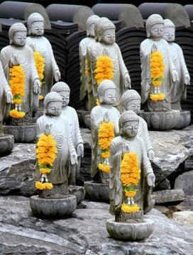 Multiple small buddha statues with yellow garlands at Wowoojongsa or Wawoo .. Stock Photos