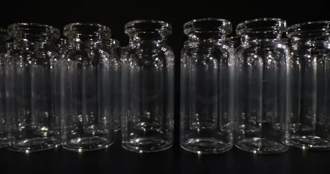 Multiple small clear glass bottles create repetitive pattern Stock Footage 312143808