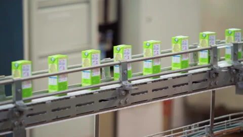 Multiple Small Green Packets are Moving on the Conveyor Line at Milk Production Stockbeeldmateriaal 271578396