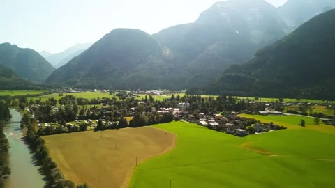 Multiple small towns and fields in green valley surrounded by forestry mountains Stock Footage 250084426