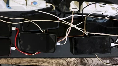 Multiple Smartphones Charging Simultaneously On Power Strips With Tangled C.. Stock Footage 341693320