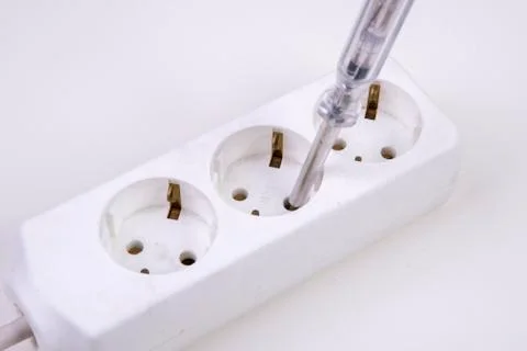 Multiple socket is tested with a voltage tester screwdriver Stock Photos