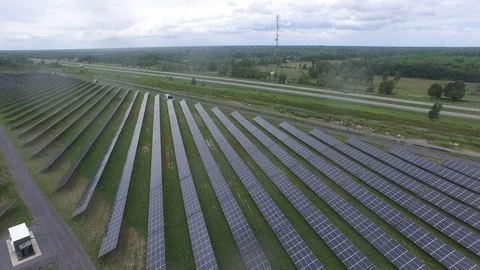 Multiple solar panels seen from a drone in flight next to highway Stock Footage 94865194