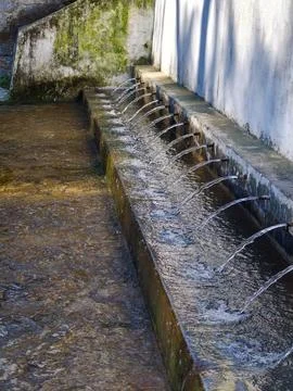 Multiple spouts streaming fresh water into stone channel Foto stock