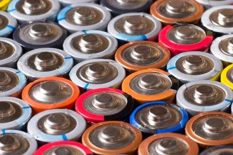 Multiple stacked aaa batteries of different color and manufacturer Stock Photos