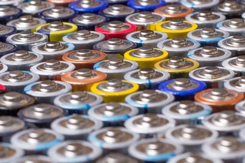 Multiple stacked aaa batteries of different color and manufacturer Stock Photos