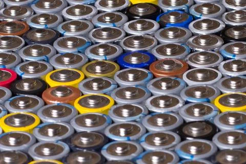 Multiple stacked aaa batteries of different color and manufacturer Stock Photos