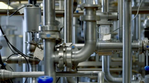Multiple steel tubes attached to the modern machinery at the dairy factory Stock Footage 292828139