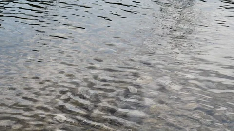 Multiple stones falling into water in slow motion Stock Footage 94686568