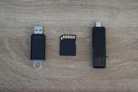 Multiple storage media devices aligned on wooden surface Stock Photos