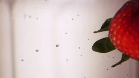 Multiple Strawberries Dropped into Water with Bubbles Stock Footage 234848276