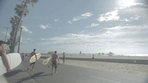 Multiple Surfers Walking To Go Surfing with Pedestrians - Huntington Beach Stock Footage 74721305