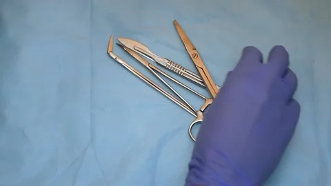 Multiple surgery instruments on blue table above view. surgeon put down surgical Stock Footage 149437636