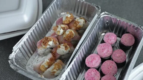 Multiple sushi dishes are arranged in takeout containers, showcasing different 库存影片 337556952