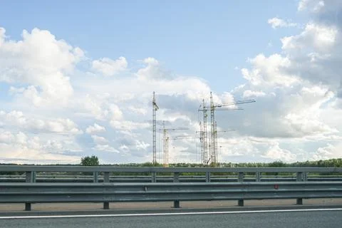 Multiple tall tower cranes at construction site with new building development. Stock Photos
