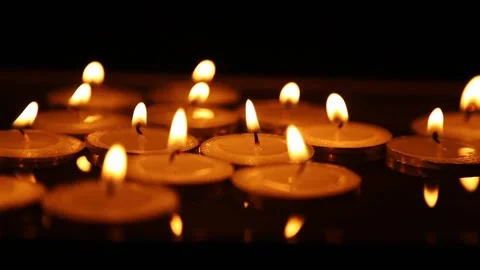 Multiple tea candles burning together with steady shifting flames Stock Footage 323436998