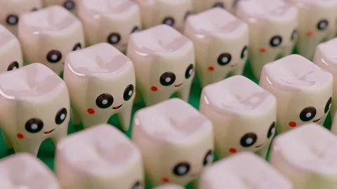 Multiple tooth characters with faces arranged in rows facing right on green.. Stockillustratie