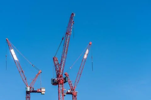 Multiple tower cranes above a concrete structure. Stock Photos