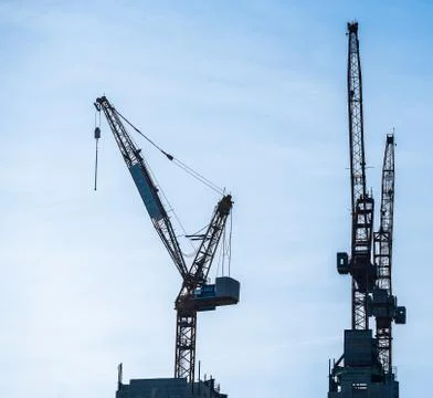 Multiple tower cranes above a concrete structure. Stock Photos